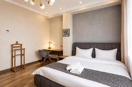 a bedroom with a large bed and a desk at Auris Hotel & Restobar in Almaty