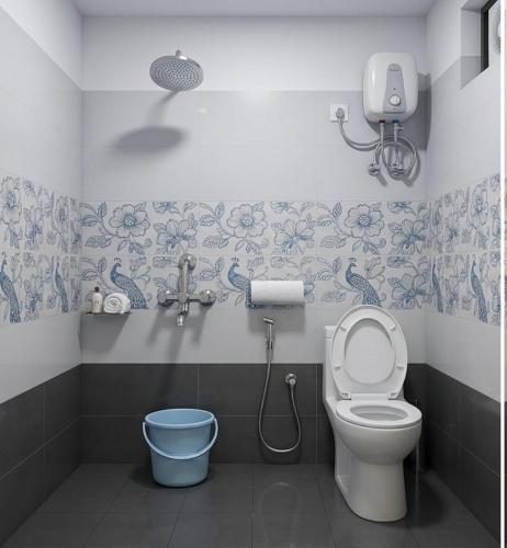 a bathroom with a toilet and a bucket at Hotel Pink Palace - Triplicane, Chennai in Chennai