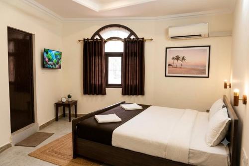a bedroom with a bed and a window at Hotel Pink Palace - Triplicane, Chennai in Chennai