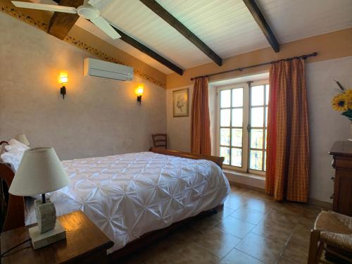 a bedroom with a large bed and a window at Villa La Rose des Vents in Tourrettes