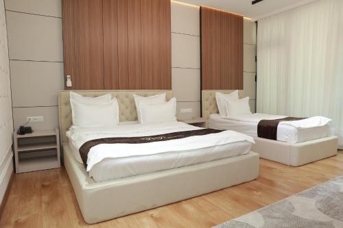 a bedroom with two beds with white pillows at Boulevard Palace Hotel in Samarkand