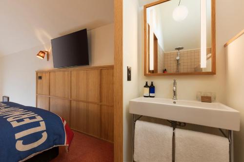 a bathroom with a sink and a bed and a mirror at Grand Mess Clermont-Ferrand in Clermont-Ferrand