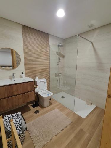 a bathroom with a toilet and a glass shower at Gondar Stays Estúdio 