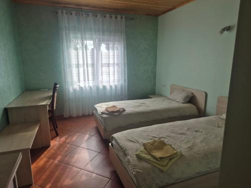a room with two beds and a desk and a window at Gintolina in Kazlų Rūda