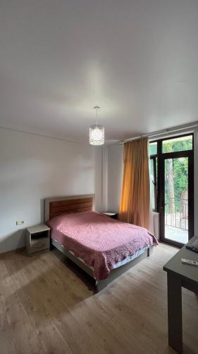 a bedroom with a pink bed and a window at Guest House in Batumi