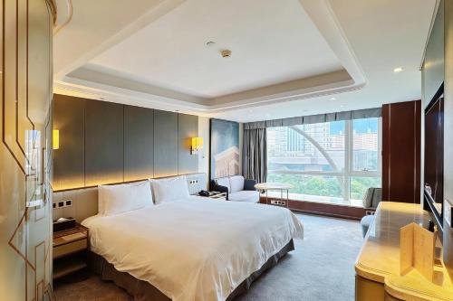 a hotel room with a bed and a large window at Oriental Riverside Bund View Hotel (Shanghai International Convention Center) in Shanghai