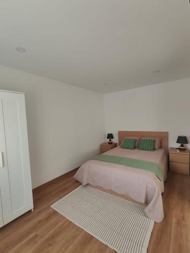 a white bedroom with a bed and two night stands at Gondar Stays T1 