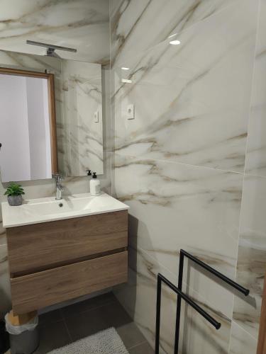 a bathroom with a sink and a marble wall at Gondar Stays T1 