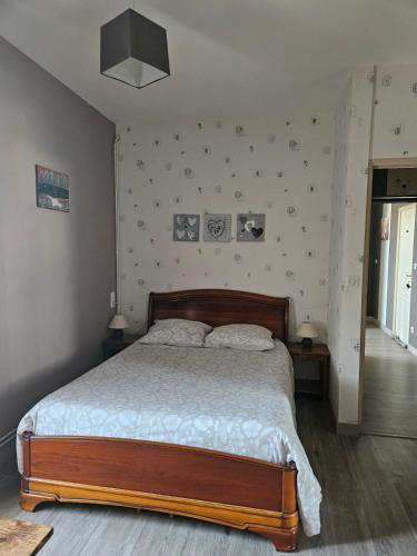 a bedroom with a bed and a wall with pictures at Chambres d'hôtes -- Le Clos de Gémozac in Gémozac
