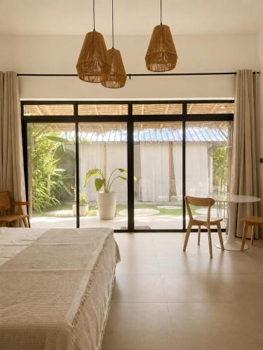 a bedroom with a bed and a table and chairs at CASA BUKO Tropical Homes El Nido in El Nido