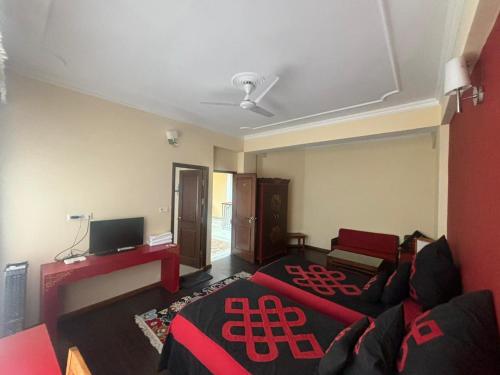 a living room with a couch and a tv at Serkong Rabsel House in Dharamshala