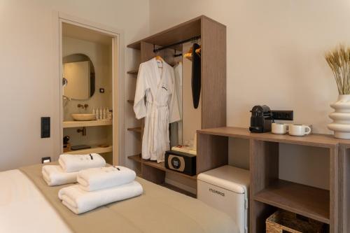 a room with a bed with towels and a mirror at Ichos Boutique Apartments in Volissos