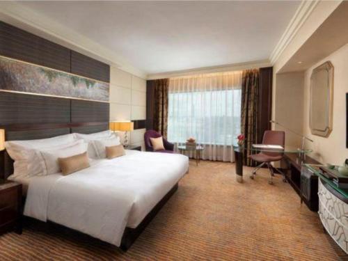 a hotel room with a large bed and a desk at StarWorld Hotel in Macau