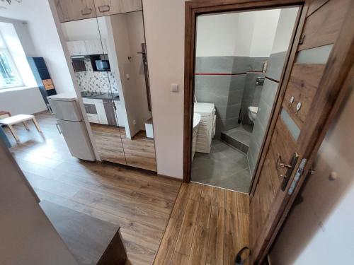 a small bathroom with a shower and a kitchen at Apartamenty Floris Bochnia in Bochnia