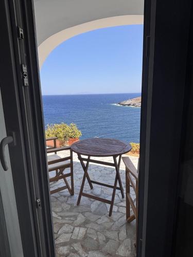 a table and chairs on a balcony with the ocean at Faros House Kythnos in Loutra