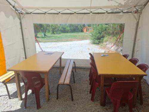 two tables and chairs in a tent with a view at Le Village des Pingouins à Porspoder in Porspoder