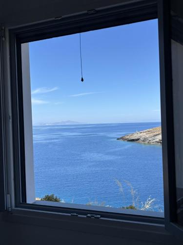 a window with a view of the ocean at Faros House Kythnos in Loutra