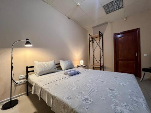 a bedroom with a large white bed with a lamp at Podil-House-Hotel in Kyiv