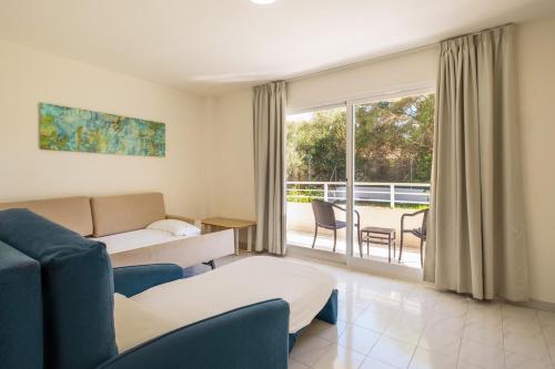a living room with a couch and a table at Cabot Club Torreblanca in Sa Coma