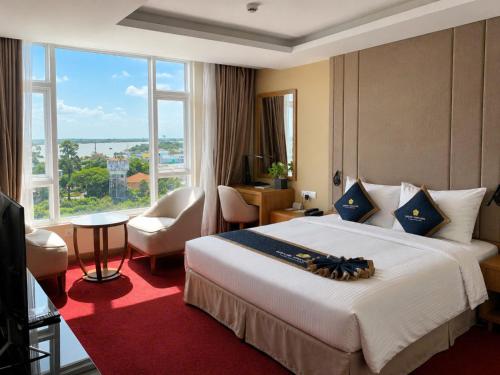 a hotel room with a large bed and a large window at Khách sạn Sài Gòn Vĩnh Long in Vĩnh Long