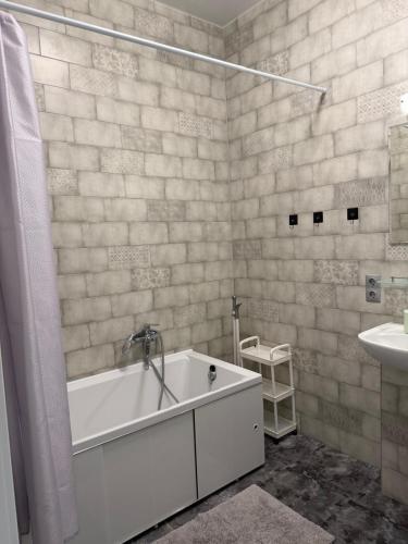 a white bath tub in a bathroom with a sink at Французский Бульвар ЖК Париж in Odesa