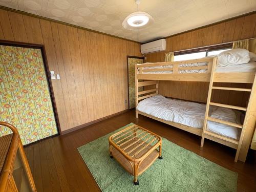 a bedroom with two bunk beds and a rug at Haraya in Nakatsugawa