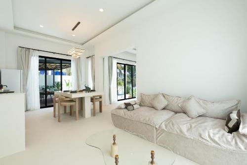 a white living room with a couch and a table at Eterno Villas in Salad Beach