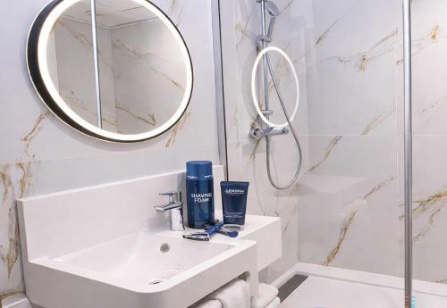 a white bathroom with a sink and a mirror at B&B HOTEL Nîmes Ville Active 3 étoiles in Nîmes