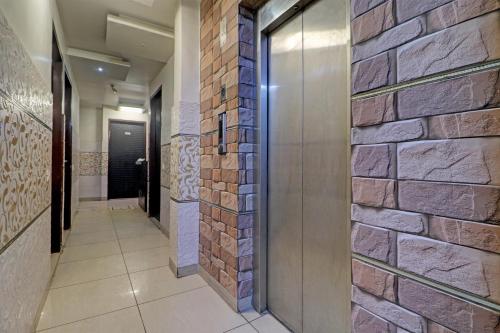 a hallway with a brick wall and a door at Collection O The Legend Hotel, Hisar in Hisār