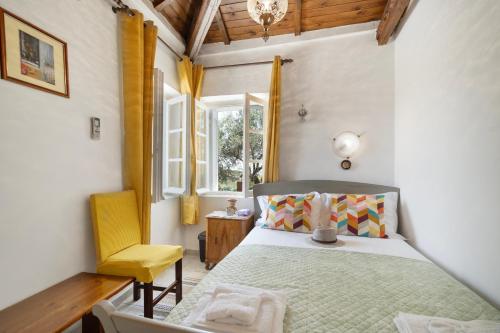 a bedroom with a bed and a yellow chair at Giannis Mountain House in Aigio