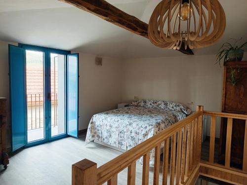 a bedroom with a bed and a wooden staircase at As Casiñas da Mina in Fechas