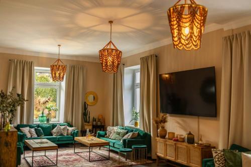ein Wohnzimmer mit einer grünen Couch und einem Flachbildfernseher in der Unterkunft BOHO HOUSE in Ustrzyki Dolne