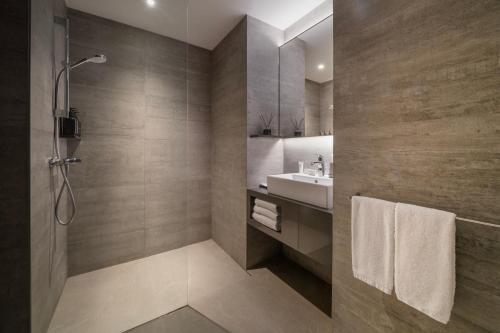 a bathroom with a sink and a shower at Oakwood Bencoolen Singapore in Singapore