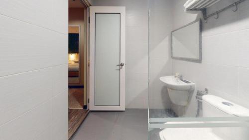 a white bathroom with a sink and a toilet at Clover Hotel in Johor Bahru