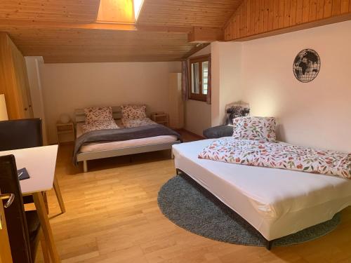 a bedroom with two beds and a tv in it at Casa da Tini in Obersaxen