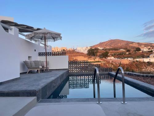 a view of a house with a pool and an umbrella at Avan Luxury Villas in Pyrgos