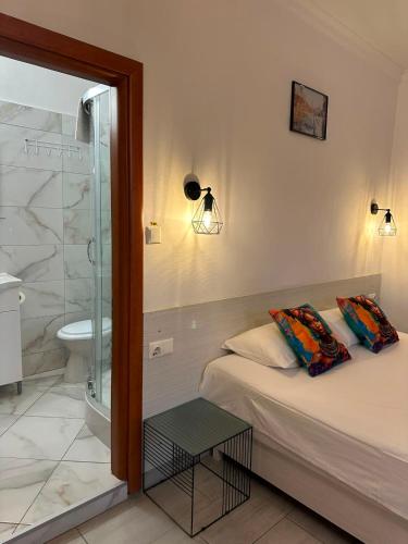 ein Schlafzimmer mit Bett und ein Badezimmer mit Dusche in der Unterkunft Pension Recidency in Oradea