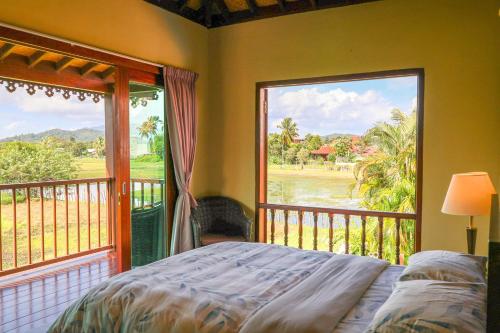 a bedroom with a bed and a large window at Cathaya Private Pool Villa - Limasan Padi in Langkawi Intl