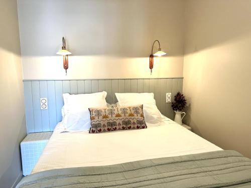 a bedroom with a large white bed with two lights at Le Petit Bijou Sète, 5 appartements in Sète