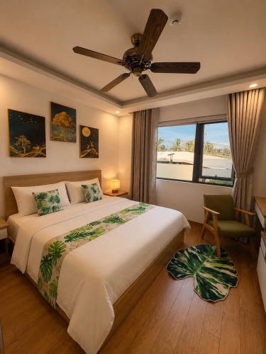 a bedroom with a large bed and a ceiling fan at Arrive Hotel & Apartment in Danang