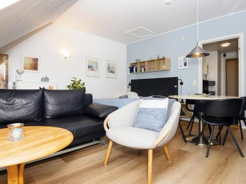 a living room with a black couch and a table at 2 person holiday home in Hejls in Hejls