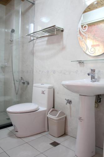 a bathroom with a toilet and a sink and a shower at Xinyue B&B in Fenglin