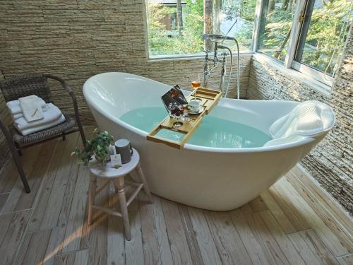 a white bath tub in a room with a window at Auberge de Primavera in Karuizawa
