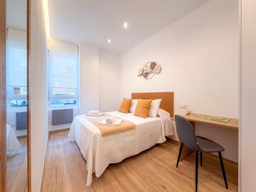 a bedroom with a bed and a desk with a chair at Apartamentos Liérganes Centro II in Liérganes