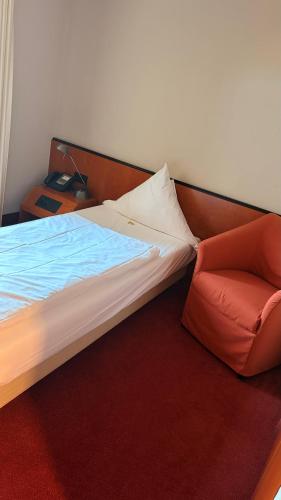 a bed and a chair in a room at Hotel zum Ritter in Fulda