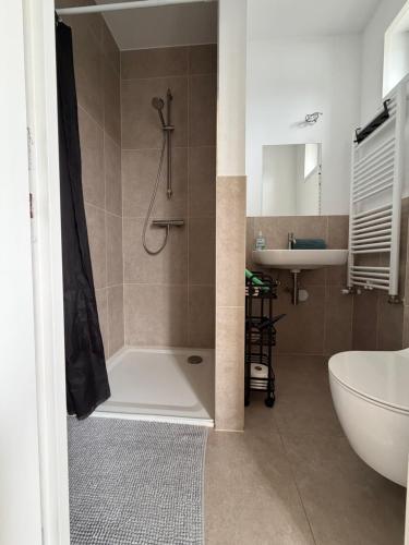 a bathroom with a shower and a tub and a sink at Weltevreden in Noordwijk