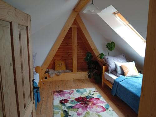 a attic room with a bed and a couch at Murań1 in Bukowina Tatrzańska