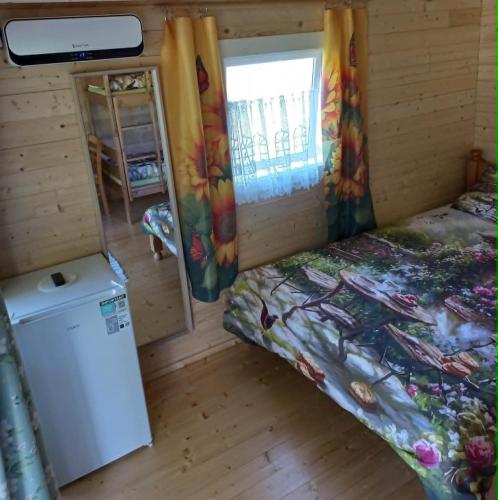 a small bedroom with a bed and a window at Muhu Garden Cabin in Suuremõisa
