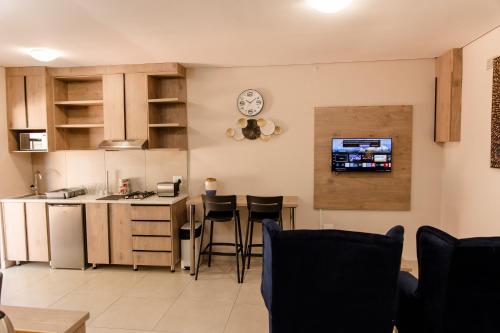a kitchen with a sink and a counter with stools at Wilkoppies Self Catering in Klerksdorp