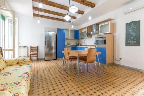 a kitchen with blue cabinets and a table and chairs at Villino Carolina in Porto Cesareo